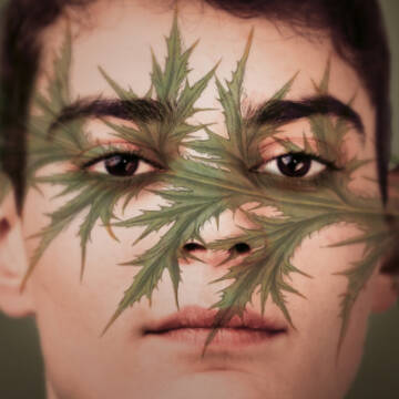 Zdjęcie portretowe mężczyzny, na twarzy znajduje się namalowana roślina