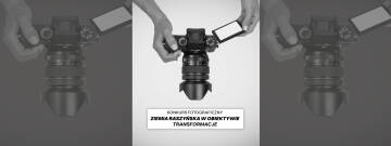 Grafika jest czarno biała. Na białym tle widać dłonie trzymające aparat fotograficzny.