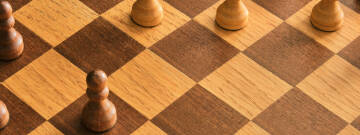 Grafika przedstawia szachownicę z pionkami