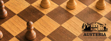 Grafika przedstawia drewnianą szachownicę z drewnianymi pionkami. Po prawej stronie znajduje się czarny logotyp Austerii